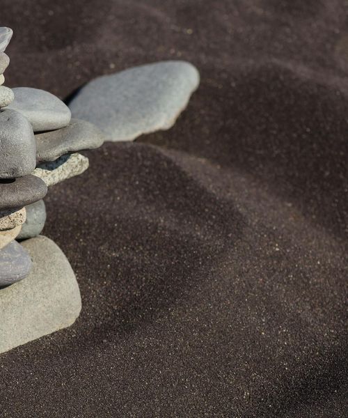 Smooth stones stacked in a zen balance against a dark background
